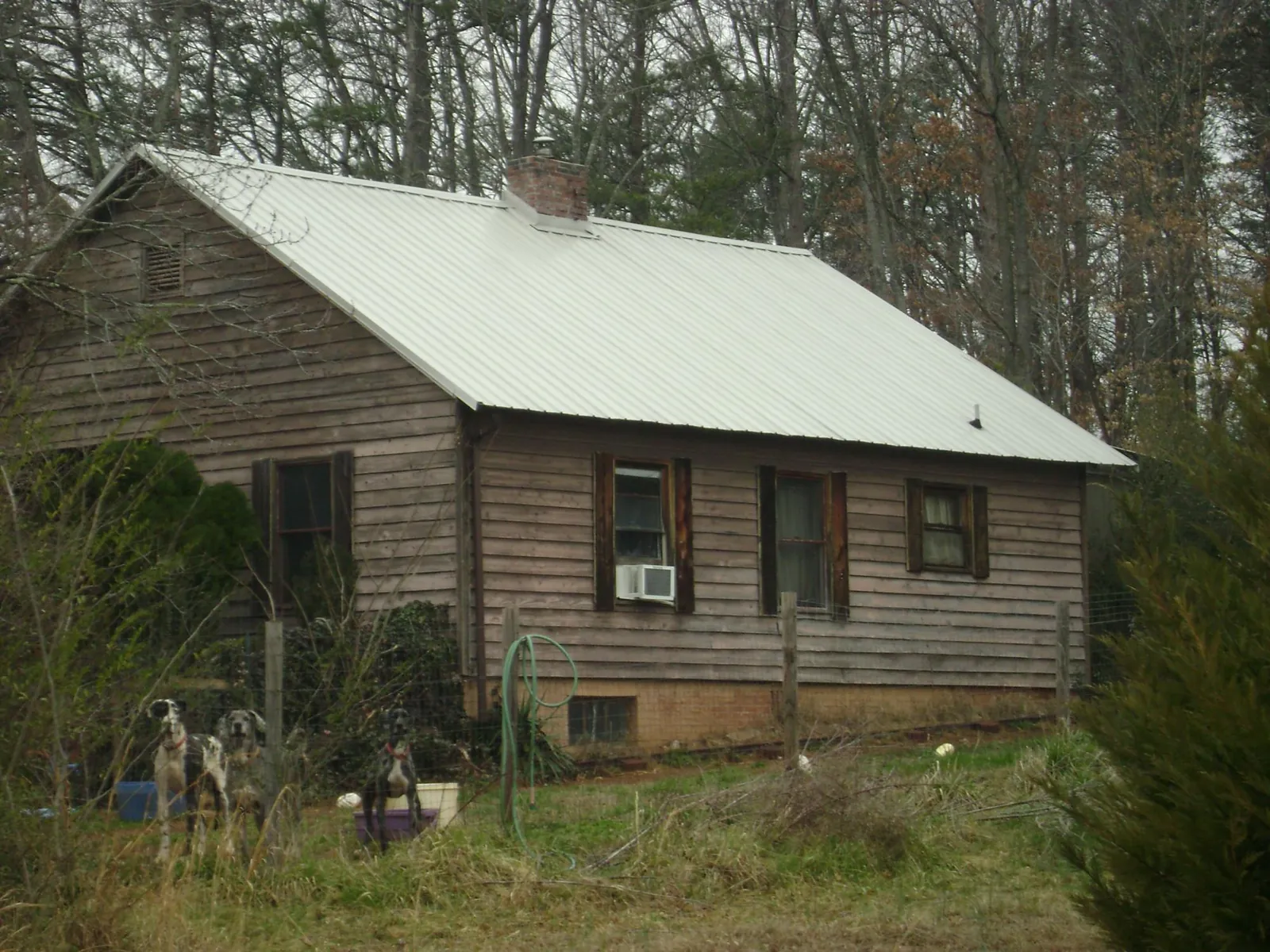 White metal roof on an old wood sided farmhouse, from a Metal Roof Installation job in Greene